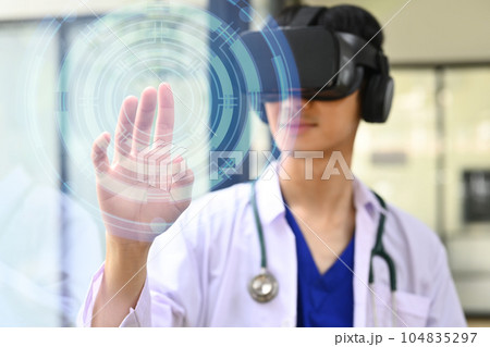 Innovative, healthcare and medical technology concept . Doctor wearing VR headset and pressing button on virtual screen 104835297