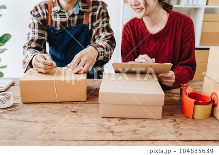 Portrait of Starting small businesses SME owners, family business check online orders Selling products working with boxes freelance work at home office, sme business online small medium enterprise. Portrait of Starting small businesses SME owners, family business check online orders Selling products working with boxes freelance work at home office, sme business online small medium enterprise. 104835639