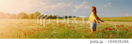 Woman in profile standing on the field with a lot of wild flowers Woman in profile standing on the field with a lot of wild flowers 104836266