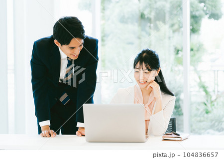 明るいオフィスで仕事をする男女の会社員 明るいオフィスで仕事をする男女の会社員 104836657