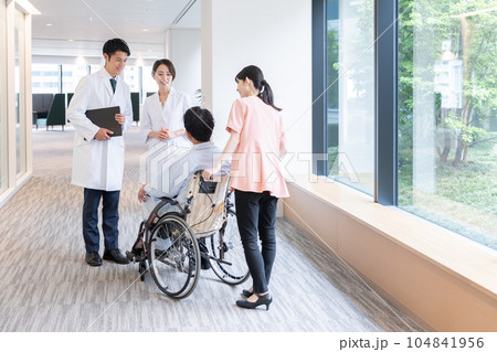 病院で車椅子に乗った入院患者と話す医者 104841956