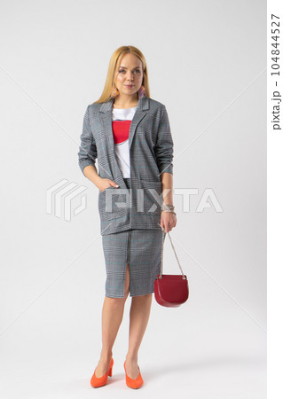 Blonde woman in elegant casual plaid office clothes with a handbag on a chain 104844527