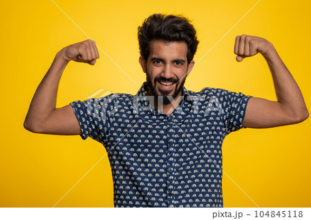 Fit sporty indian man showing biceps and looking confident, feeling power strength success win 104845118