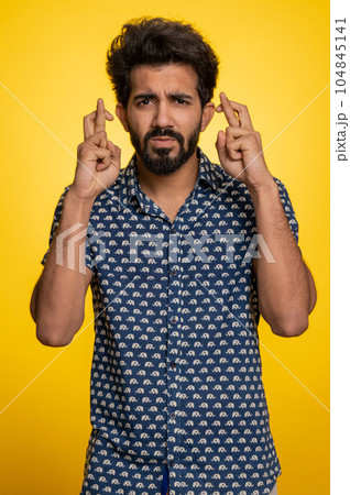 Indian man crossed fingers asking good luck, wishing good exam results, win victory lottery jackpot 104845141
