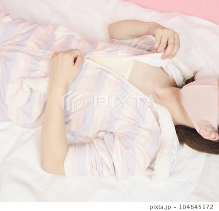 パジャマのファスナーを下ろす若い女性 パジャマのファスナーを下ろす若い女性 104845172