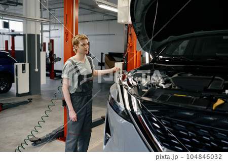 Young man mechanic raising broken car up on automated lifting machine Young man mechanic raising broken car up on automated lifting machine 104846032