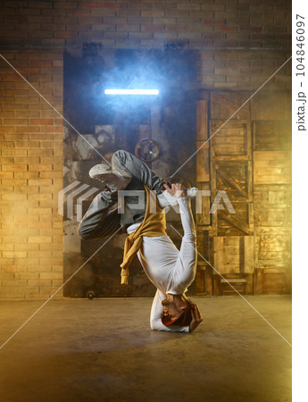 Handsome young man developing freeze over dance studio background Handsome young man developing freeze over dance studio background 104846097