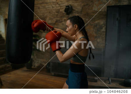 Healthy strong girl fighter boxing with punching bag having workout training Healthy strong girl fighter boxing with punching bag having workout training 104846208