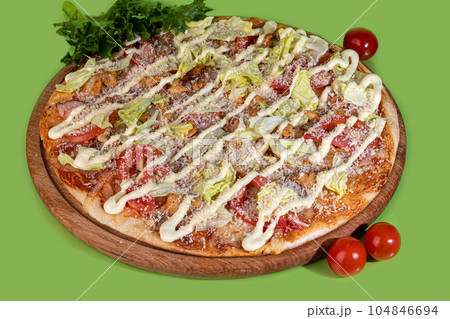 Pizza with bacon cheese and herbs on a wooden plate with cheese and cherry tomatoes. On a colored Pizza with bacon cheese and herbs on a wooden plate with cheese and cherry tomatoes. On a colored 104846694