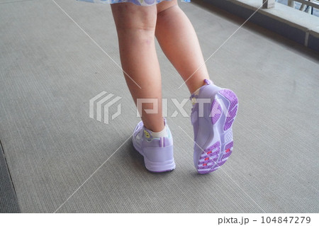 雨の日対策で履いている防水スニーカー。小学4年生の女の子が履いている様子。 104847279