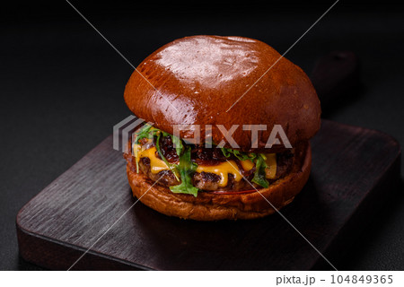 Burger with juicy beef cutlet, cheese, tomatoes, salt, spices and herbs 104849365