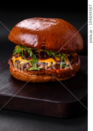 Burger with juicy beef cutlet, cheese, tomatoes, salt, spices and herbs 104849367