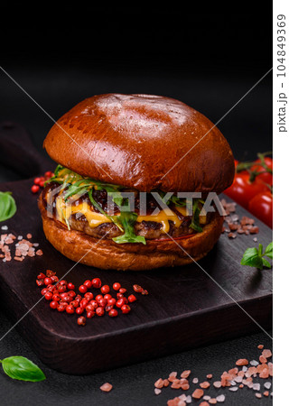 Burger with juicy beef cutlet, cheese, tomatoes, salt, spices and herbs 104849369