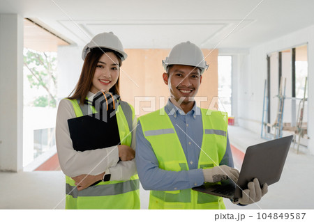 multi ethnic engineer brainstorming and measuring for cost estimating on blueprint and floor plan drawings about design architectural and engineering for houses and buildings. 104849587