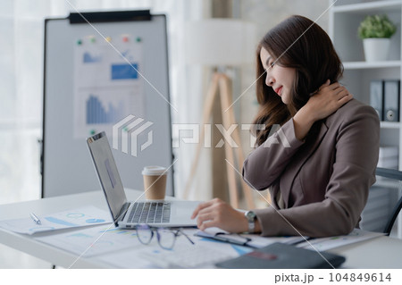 Portrait of a young Asian woman suffering from acute headache and occipital pain from sitting for a long time at work 104849614