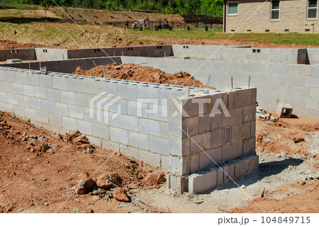 Masonry building foundation walls are located near house surrounded by dredged soil. Masonry building foundation walls are located near house surrounded by dredged soil. 104849715