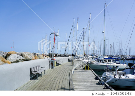Elegant and modern yacht marina with moored to a pier sailboats and cutters on the coast of Denmark Elegant and modern yacht marina with moored to a pier sailboats and cutters on the coast of Denmark 104850148