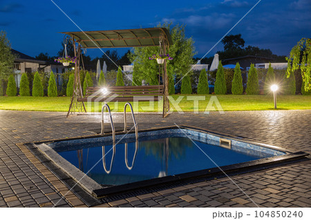 Small outdoor swimming pool in the evening. Small outdoor swimming pool in the evening. 104850240