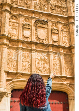 Looking for the frog and skull in Salamanca university plateresque facade. Latin middle-aged woman Looking for the frog and skull in Salamanca university plateresque facade. Latin middle-aged woman 104851145