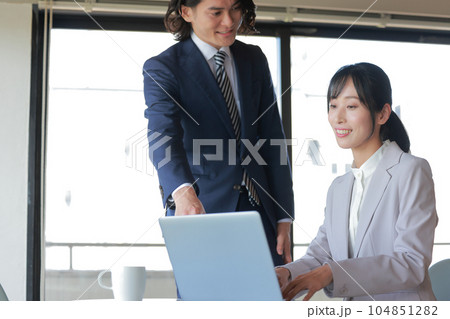 資料作成するビジネスウーマンに助言するビジネスマン_1 104851282