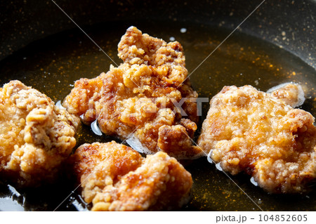 残った揚げ物(鶏唐揚げ)リメイク調理シーン。卵とじするためだし汁の入ったフライパンで煮る。 残った揚げ物(鶏唐揚げ)リメイク調理シーン。卵とじするためだし汁の入ったフライパンで煮る。 104852605