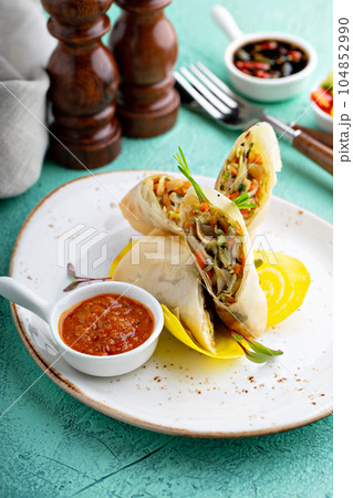 Asian cuisine spring rolls with spicy sauce 104852990