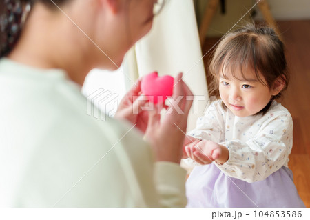 女の子にハートを渡すお母さん 104853586