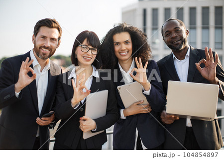 Happy entrepreneurs posing together on camera on fresh air Happy entrepreneurs posing together on camera on fresh air 104854897