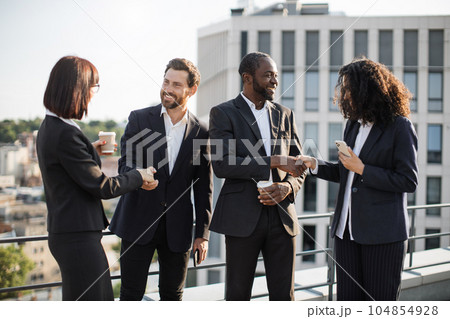 Smiling investors shaking hands after successful debates 104854928