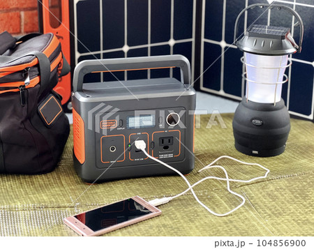 スマホに充電中のポータブル電源とソーラーパネルとライト 104856900