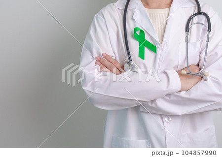 Doctor with green Ribbon for world Mental Health Day, Liver, Gallbladders, bile duct, cervical, kidney Cancer and Lymphoma Awareness month. Healthcare and world cancer day concept 104857990