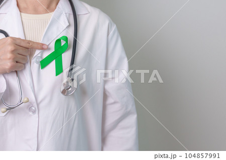 Doctor with green Ribbon for world Mental Health Day, Liver, Gallbladders, bile duct, cervical, kidney Cancer and Lymphoma Awareness month. Healthcare and world cancer day concept 104857991