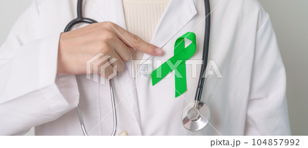 Doctor with green Ribbon for world Mental Health Day, Liver, Gallbladders, bile duct, cervical, kidney Cancer and Lymphoma Awareness month. Healthcare and world cancer day concept 104857992