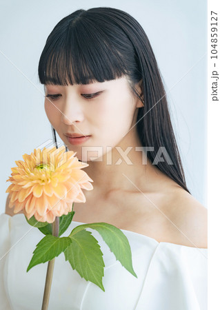 オフショルドレスを着て花を持った女性のポートレート 104859127