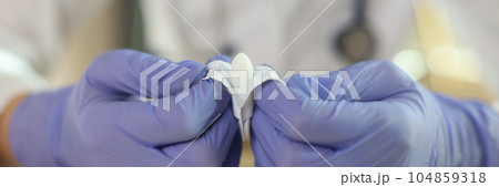 Gloved doctor opens suppositories for anal or vaginal use. 104859318