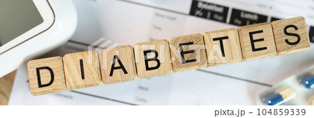 Word DIABETES with drugs, glucose meter and blood sugar tests, top view. 104859339