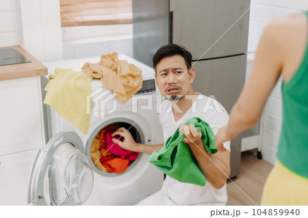 Funny crying face reaction of husband being forced to wash clothes by wife. Funny crying face reaction of husband being forced to wash clothes by wife. 104859940