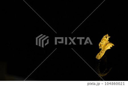 isolated golden dragon ring on black background 104860021