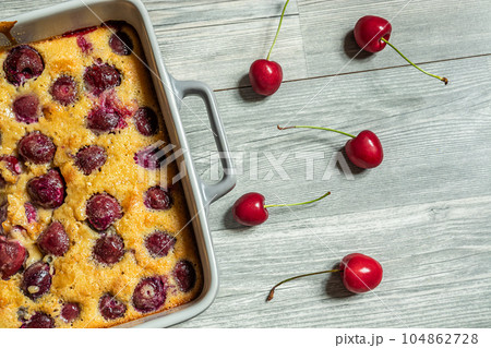 Clafoutis cherry pie - traditional french tart in a baking dish on the table, top view Clafoutis cherry pie - traditional french tart in a baking dish on the table, top view 104862728