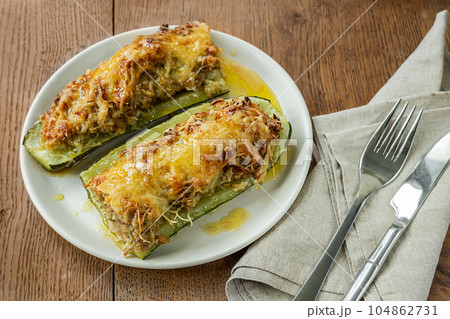 Homemade stuffed zucchini, baked with meat, onions, herbs and cheese on the wooden table, top view 104862731