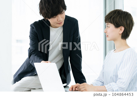 パソコン作業を指示する若手社員 104864453