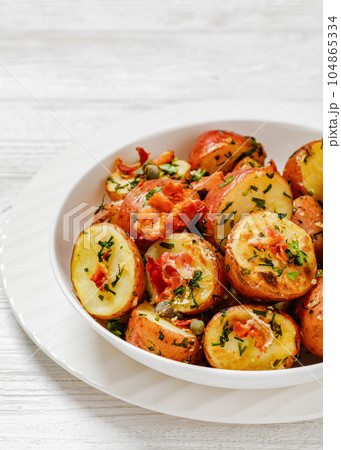 Herbs Garlic Potatoes in white bowl, top view 104865334