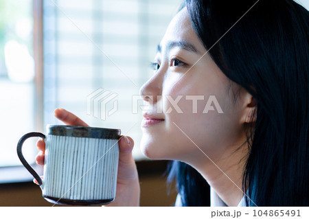 部屋でコーヒーを飲んでくつろぐ女子高生 104865491