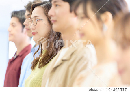 整列して話を聞く若いビジネスパーソンの横顔 整列して話を聞く若いビジネスパーソンの横顔 104865557