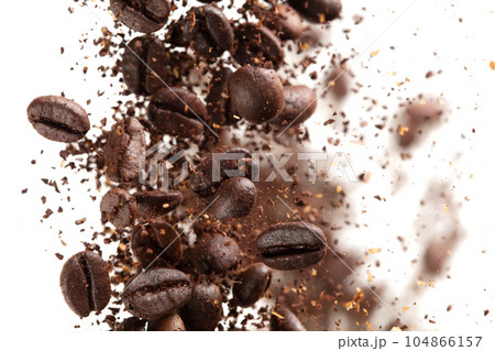 Coffee bean powder fly explosion, Coffee crushed ground float pouring, wave like smoke smell. Coffee bean powder splash throwing in mid Air. White background Isolated selective focus blur Coffee bean powder fly explosion, Coffee crushed ground float pouring, wave like smoke smell. Coffee bean powder splash throwing in mid Air. White background Isolated selective focus blur 104866157