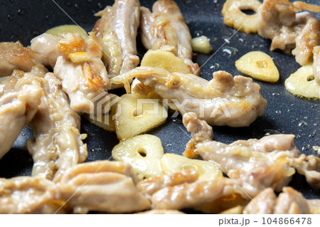 せせりとガーリックの炒め物。鶏肉(若鶏セセリ)とニンニクをフライパンで炒める調理シーン。 せせりとガーリックの炒め物。鶏肉(若鶏セセリ)とニンニクをフライパンで炒める調理シーン。 104866478