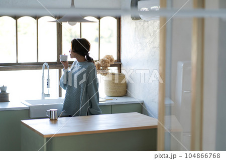 キッチンでコーヒーを飲む女性 104866768