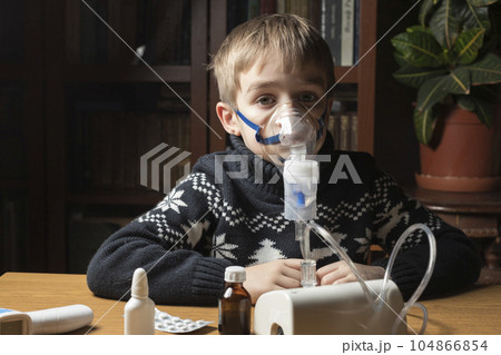 A sick child does inhalation. Inhales the medicine through the mask. Prevention of lung diseases 104866854