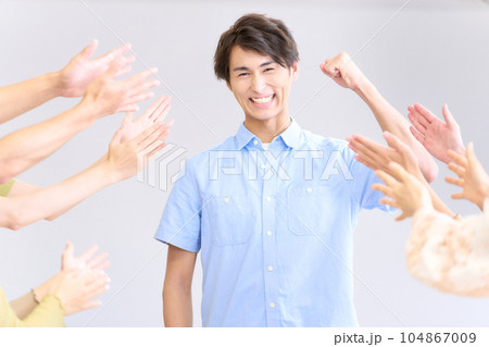 称賛を受けてガッツポーズを決める若い男性 104867009