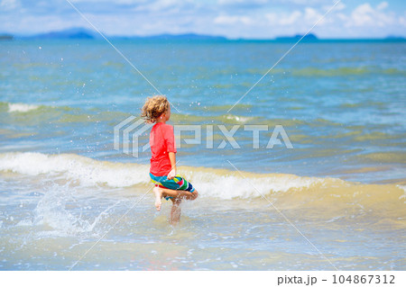 Kids play on tropical beach. Sand and water toy. 104867312